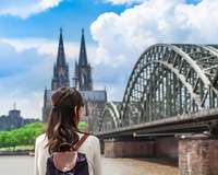 Chinesische Touristin blickt auf Deutzer Brücke und den Kölner Dom