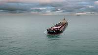 Containerschiff leer vor Wolken