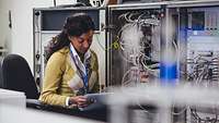 Servermitarbeiter Frau vor Server