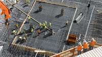 Luftbild einer Baustelle mit Arbeitern in Warnwesten
