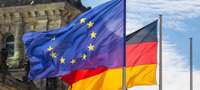 Die EU- und die deutsche Flagge wehen vor dem Reichstag