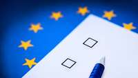 Europawahl: Stift mit Wahlzettel auf einer EU-Flagge