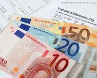 Verdienstabrechnung bedeckt mit mit 10-, 20- und 50-Euro-Banknoten