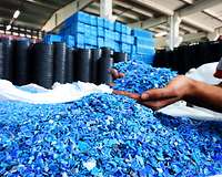 blaue Kunststoff-Rezyklate in Händen