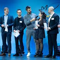 Gruppe von Azubis, in der Mitte Moderator Schölermann mit Mikro