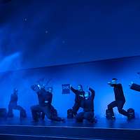 Tanzgruppe auf der Bühne in blauem Licht