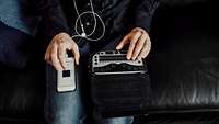 Mann nutzt Brailletastatur für sein Smartphone