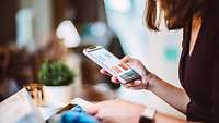 Frau bestellt via App auf dem Smartphone Kleidung