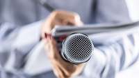 Journalist mit Block und Mikro