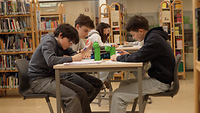 Platz 2 Auslandsschulwettbewerb: Belgien-Großbritannien Schülerinnen und Schüler arbeiten an Tischen in einer Bibliothek