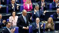 Friedrich Merz stehend umringt von applaudierenden Parteikollegen