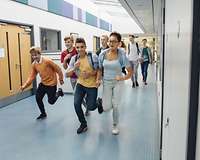 Jugendliche laufen einen Schulflur entlang