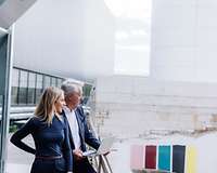 Nachfolge - Senior und junge Frau auf Fabrikgelände