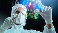 Wissenschaftler mit Maske und Schutzbrille bearbeitet ein Hologramm 