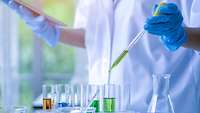 Chemielaborant pipettiert Flüssigkeiten