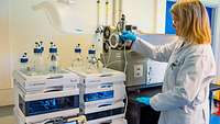 Frau im Laborkittel an Hightech-Apparatur