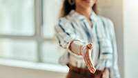 Junge Frau streckt Hand aus