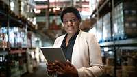 Afrikanische Geschäftsfrau mit Tablet im Lager