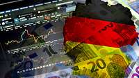 Geldscheine und eine Deutschlandkarte in schwarz-rot-gold 