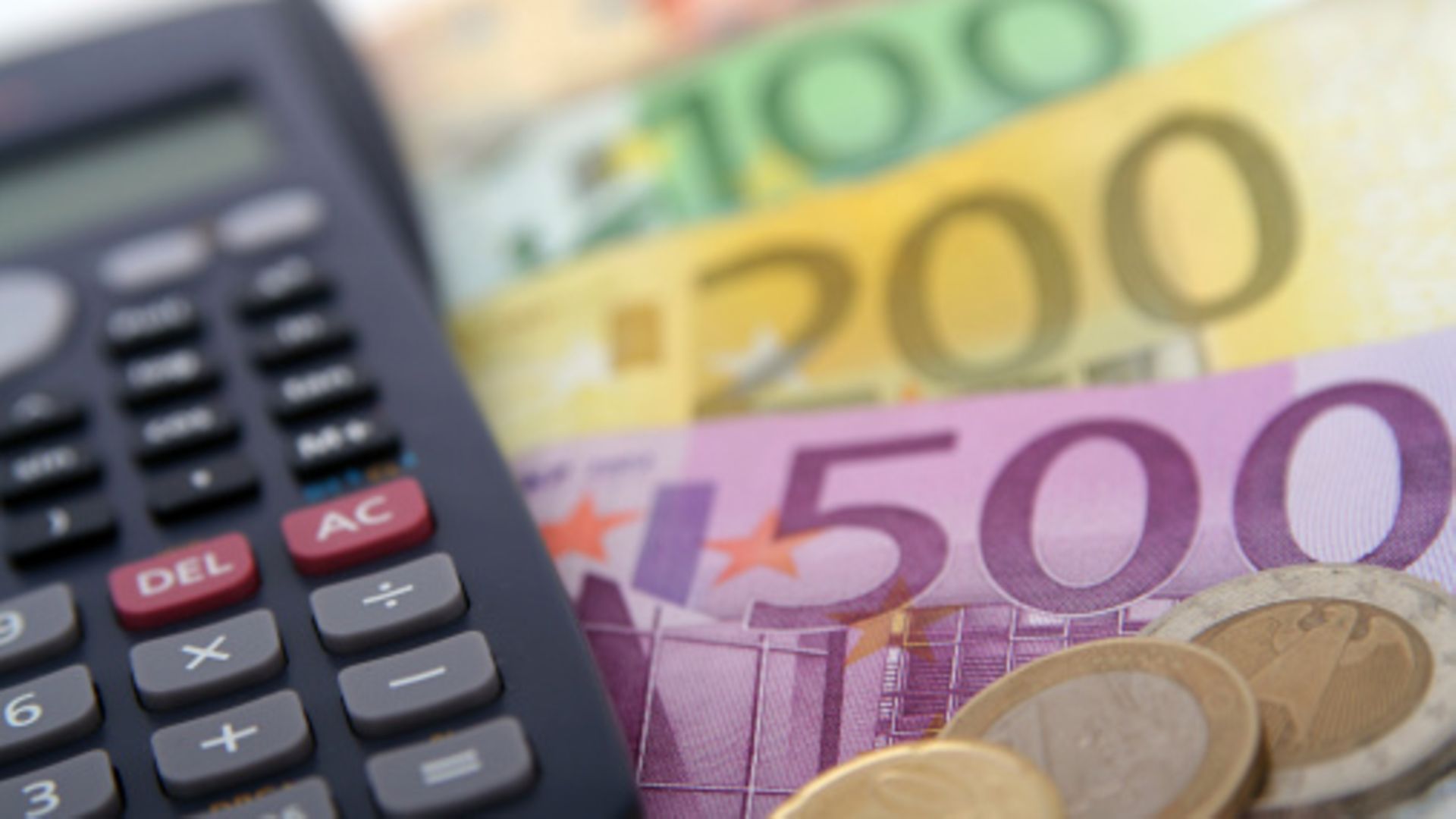 Euroscheine und -münzen neben Taschenrechner