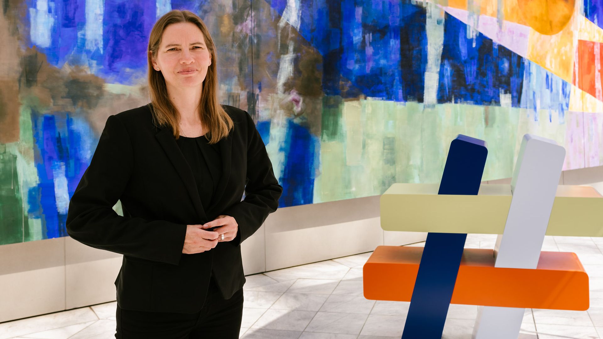 Frau steht vor Gemälde.