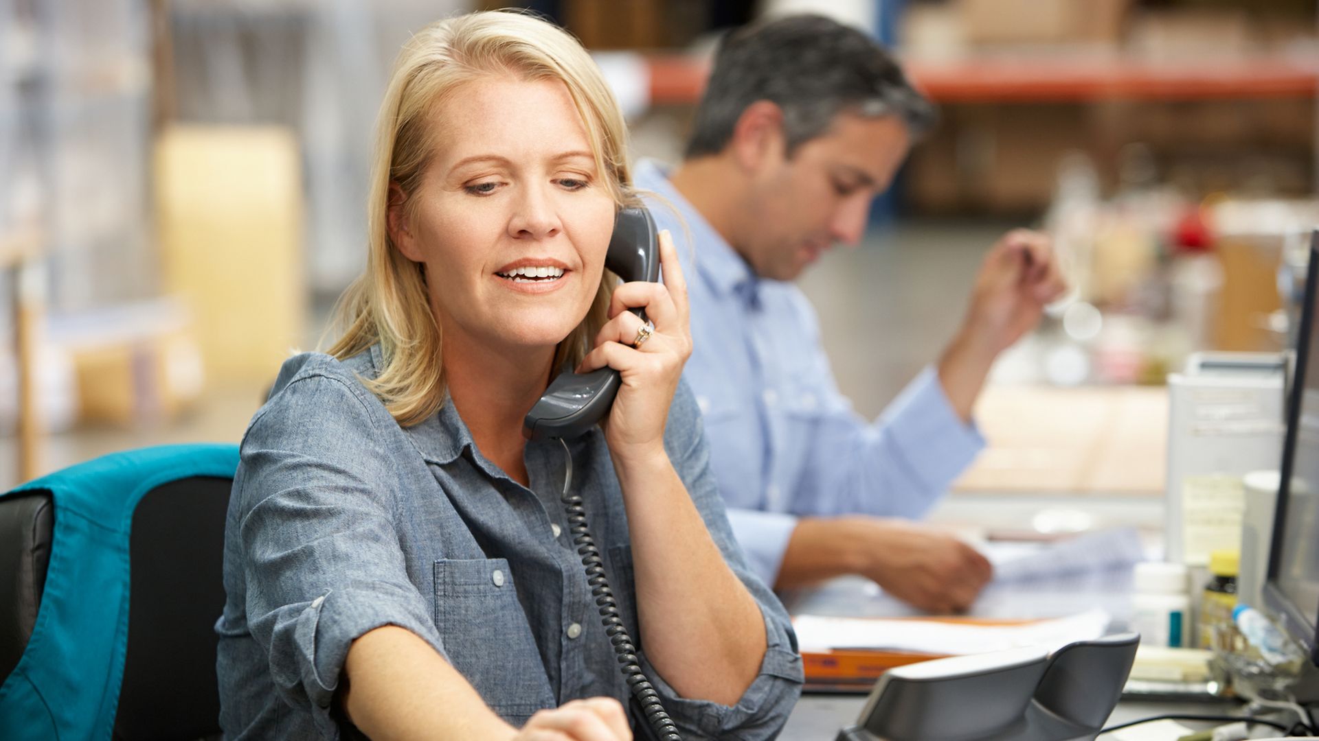 Büroangestellte am Telefon und sucht Visitenkarte