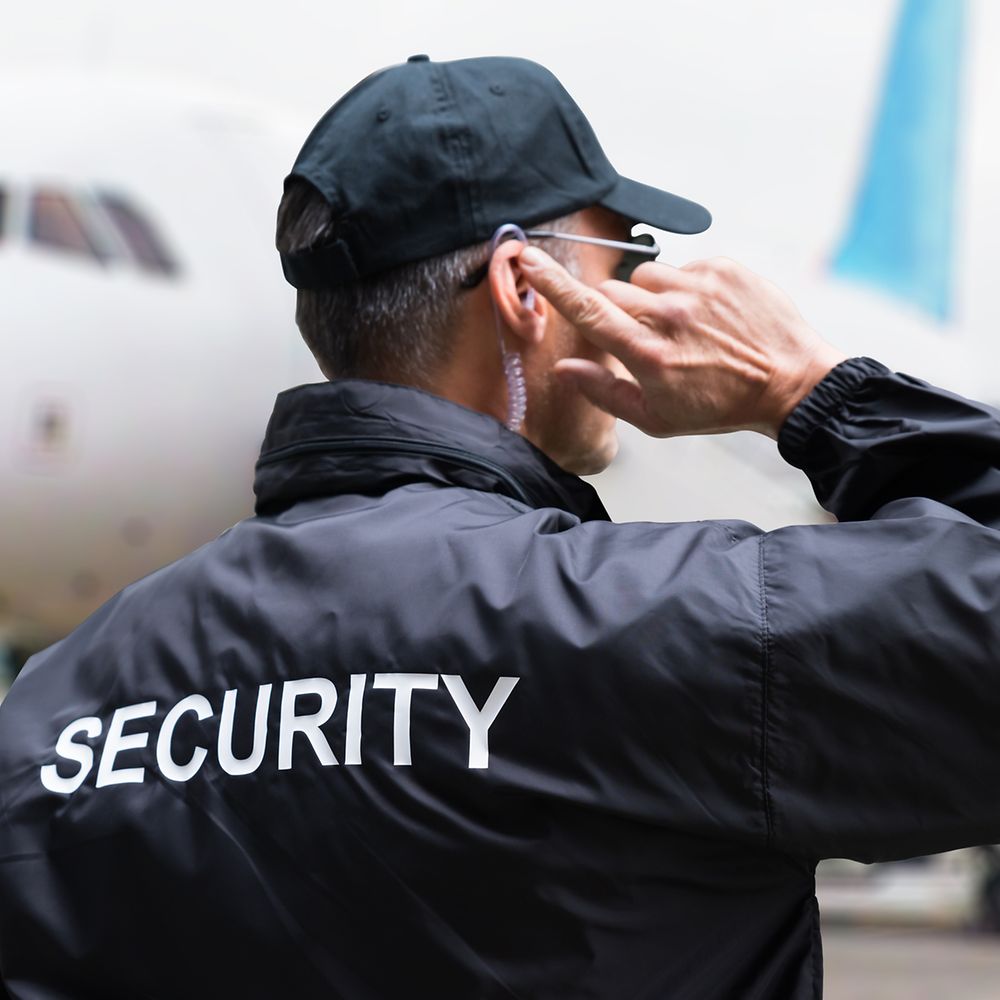 Mann mit Security-Jacke mit Knopf im Ohr 