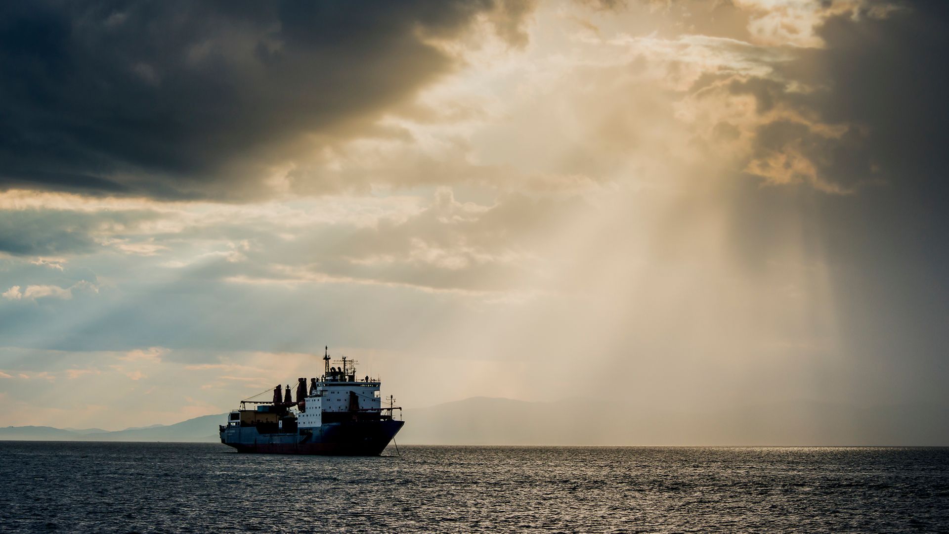Handelsschiff auf Meer mit Lichtstrahl 