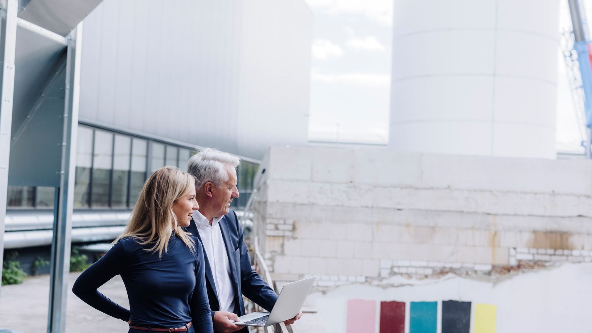 Nachfolge - Senior und junge Frau auf Fabrikgelände