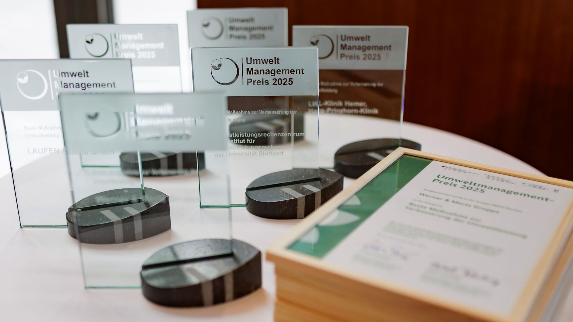 Die Trophäen der EMAS Umweltmanagementpreise 2025 auf einem Tisch