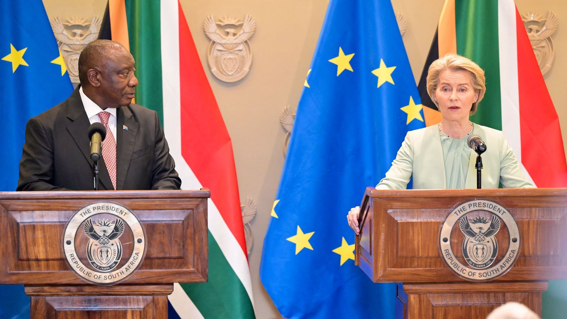 Präsident Ramaphosa und Kommissionspräsidentin von der Leyen an Rednerpulten vor Flaggen