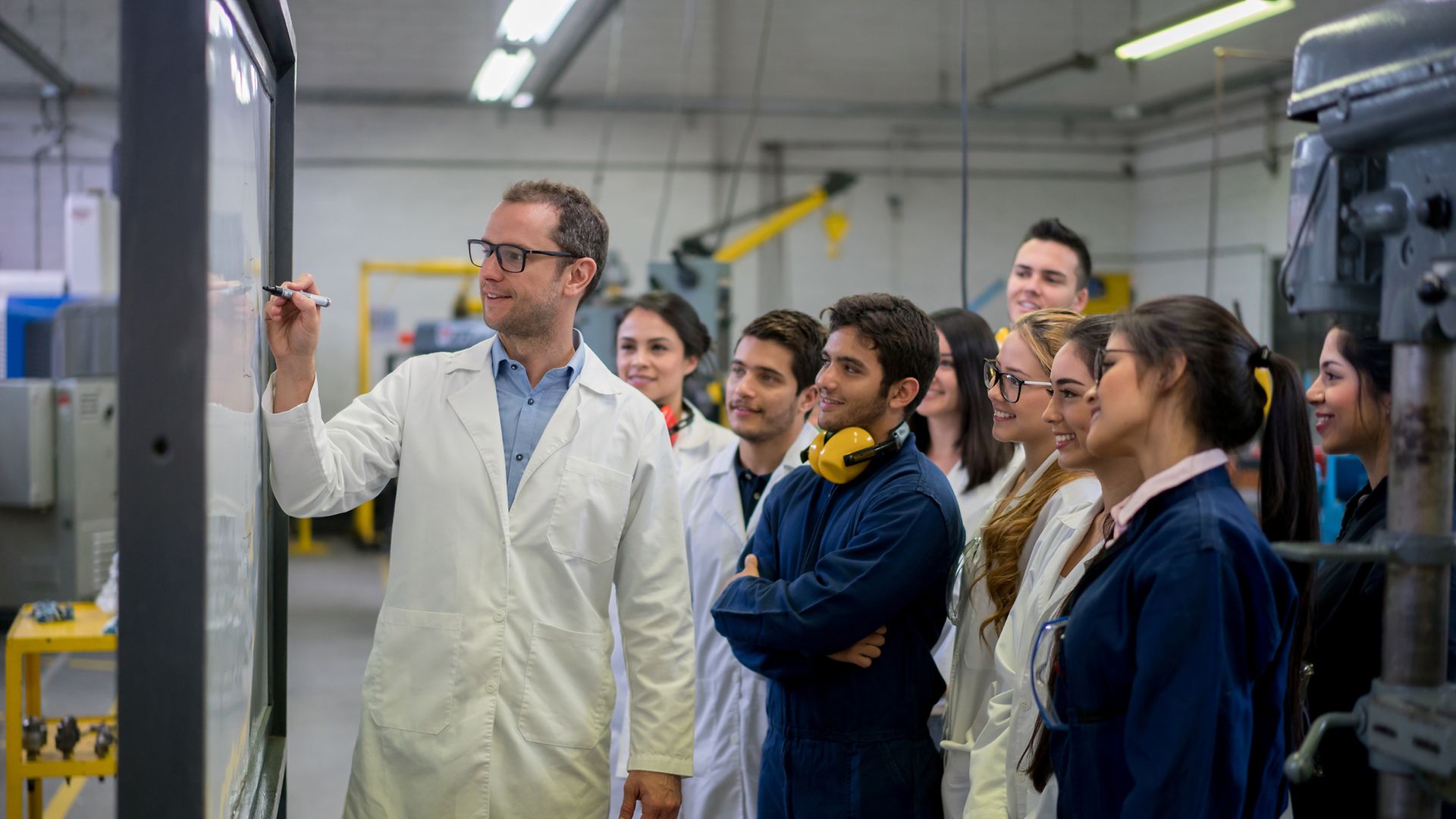 Dozent und Studierende in Werkhalle