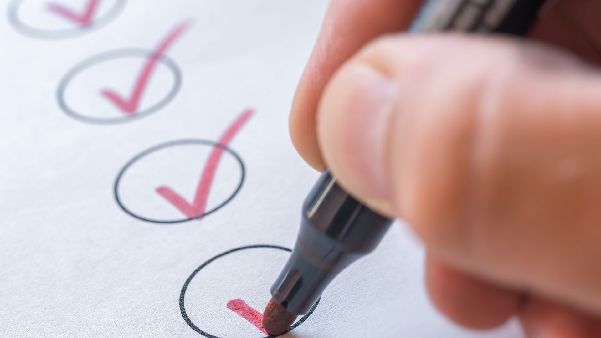 Hand mit Stift hakt Kreise ab 