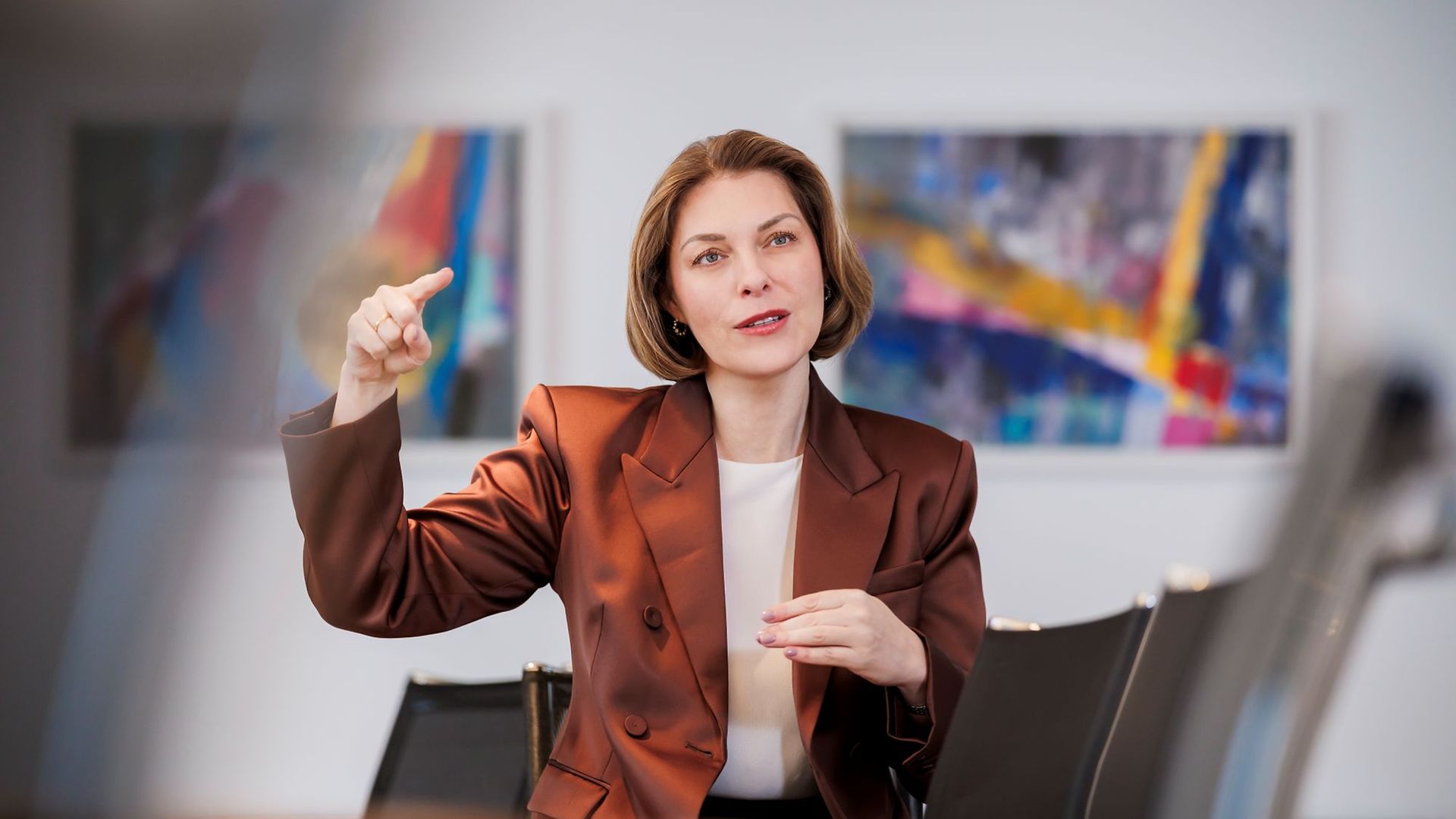 Helena Melnikov in braunem Blazer gestikuliert