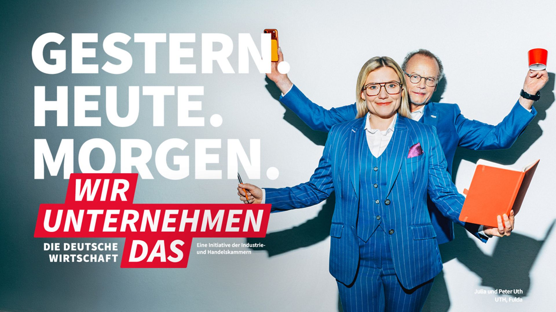 Kampagnenmotiv "Wir unternehmen das", Frau und Mann im Anzug mit Büromaterial