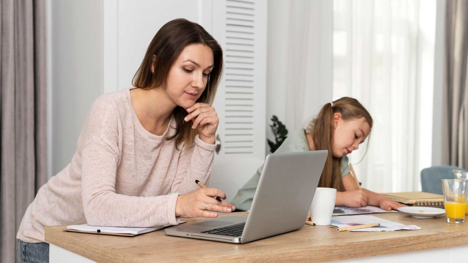 Mutter arbeitet, Kind sitzt neben ihr