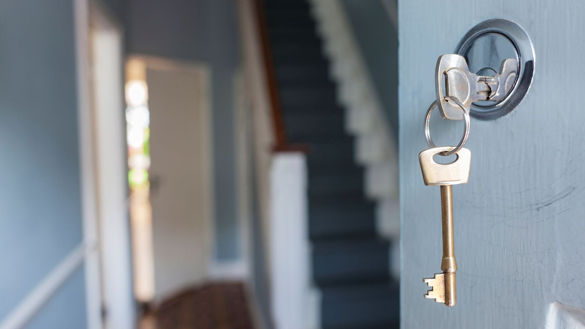 Wohnungsschlüssel in einer geöffneten Haustür
