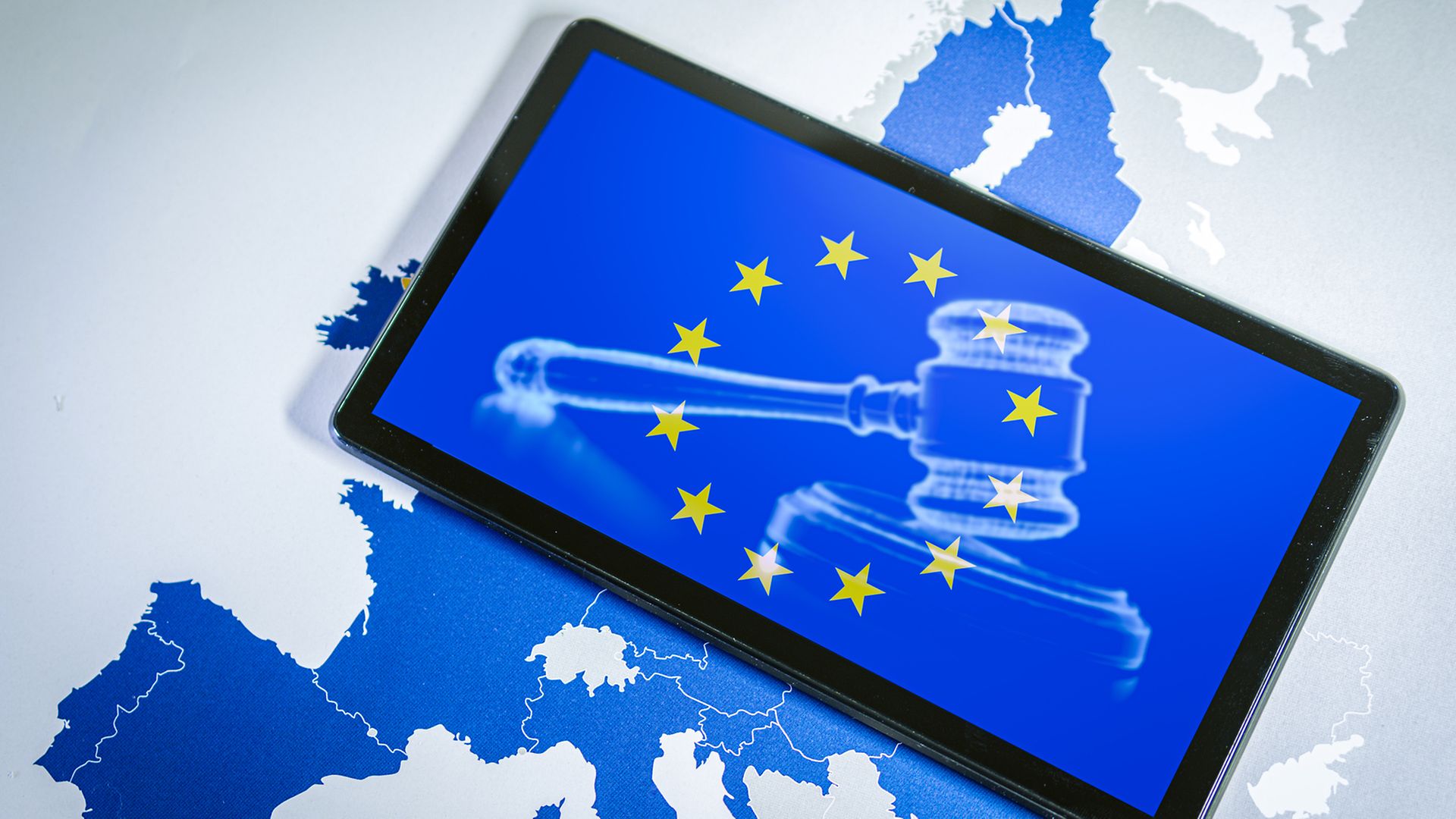 EU-Karte mit Tablet, auf dem ein Richterhammer mit EU-Sternen zu sehen ist