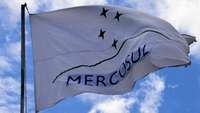 Flagge Mercosur / Mercosul weht im Wind vor blauem Himmel mit einzelnen Wolken