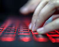 Hände auf rot leuchtender Tastatur