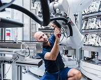 Man schraubt an einem Roboterarm