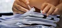 Hände blättern in einem Stapel von Schnellheftern