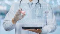 Mediziner hält ein Tablet vor dem Bauch, aus dem digitale Symbole und Grafiken aufsteigen