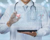Mediziner hält ein Tablet vor dem Bauch, aus dem digitale Symbole und Grafiken aufsteigen