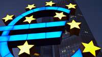 Erleuchtetes Euro-Symbol vor der EZB-Zentrale in Frankfurt im Dunklen