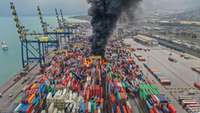 Brennende und umgeworfene Container im Hafen von Hatay