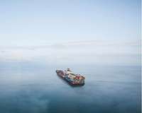 Mit vielen Containern beladener Frachter auf hoher See