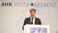 Bundeswirtschaftsminister Robert Habeck steht am Sprecher-Podest bei AHK-Weltkonferenz 2023